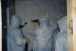 Students remove mold contaminated wallboard in containment mock up at mold remediation seminar
